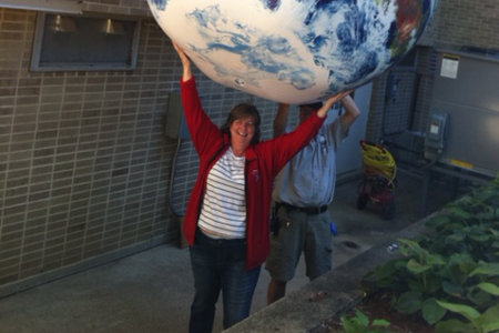 Laura Shere holding a giant inflated globe