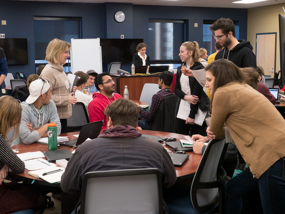 Student delegates begin the negotiation process, with "UN Leader" Professor Ann Terlaak overseeing the action. Photo by Nathan Jandl. 