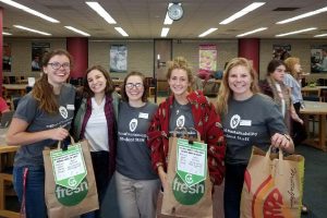 Office of Sustainability interns holding compost bags at the College Library #StudyStrong Academic Resource Fair, where signage for #RecycleRight was initially piloted. Photo by Nathan Jandl.