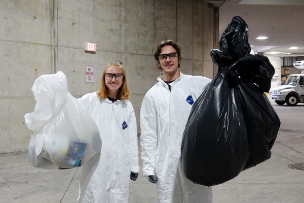 Office of Sustainability student interns Natalie Brunner and Jackson Webster hoist trash and recycling bags during a trash audit.