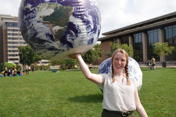 UW-Madison graduate student Audrey Stanton holds up an inflatable earth during Sustain-a-Bash 2019.