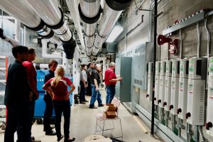 Students and staff assess an electrical panel in preparation for a Green Fund project.