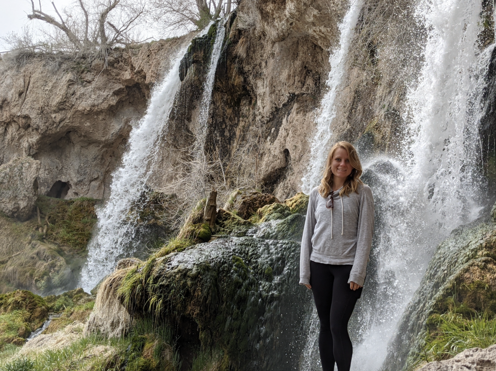 Breana Nehls stands in front of waterfall